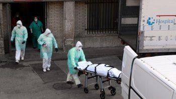 Trabajadores de salud trasladan el cadáver de uno de los fallecidos por el coronavirus COVID-19 en el hospital Gregorio Maranon, en Madrid, España, el 25 de marzo de 2020.