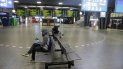 Dos personas se sientan aisladas en una estación de trenes en Bruselas. Dos personas se sientan aisladas en una estación de trenes en Bruselas.