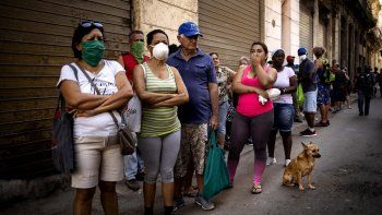 La gente hace fila para comprar alimentos, algunos usando mascarillas como precaución contra la propagación del nuevo coronavirus, en La Habana, Cuba, el martes 24 de marzo de 2020. 