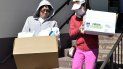 Dos mujeres salen de una pescadería con cajas de mariscos. Dos mujeres salen de una pescadería con cajas de mariscos.