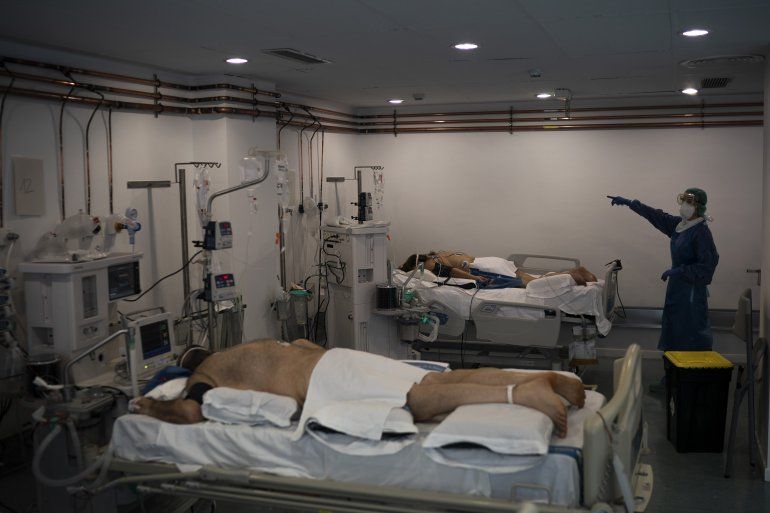Una trabajadora de salud hace una señal con la mano mientras atiende a pacientes enfermos de COVID-19 en una biblioteca convertida en unidad de cuidados intensivos en el hospital Germans Trias i Pujol en Badalona