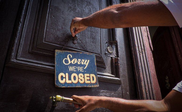 Una persona coloca el cartel de cerrado a las puertas de un café, en La Habana, Cuba. 