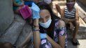 Una mujer, con mascarilla y guantes para protegerse del coronavirus, espera en el exterior de un comedor benéfico gestionado por monjas para recibir algo de comida, en la barriada de Petare, en Caracas, Venezuela, el 30 de abril de 2020. Una mujer, con mascarilla y guantes para protegerse del coronavirus, espera en el exterior de un comedor benéfico gestionado por monjas para recibir algo de comida, en la barriada de Petare, en Caracas, Venezuela, el 30 de abril de 2020.