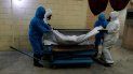 Trabajadores con trajes de protección levantan el cuerpo de una persona que murió de coronavirus antes de colocarlo en un horno de cremación en el cementerio Mausoleos San Cristóbal, en Ecatepec, Estado de México, al noreste de la Ciudad de México, el jueves 21 de mayo de 2020. Trabajadores con trajes de protección levantan el cuerpo de una persona que murió de coronavirus antes de colocarlo en un horno de cremación en el cementerio Mausoleos San Cristóbal, en Ecatepec, Estado de México, al noreste de la Ciudad de México, el jueves 21 de mayo de 2020.