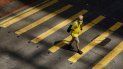Un hombre cruza un paso de peatones en China. Un hombre cruza un paso de peatones en China.