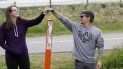 Kris Browning (izq) y su esposo Tim Browning se dan la mano por sobre un poste que marca el límite entre EEUU y Candá cerca de Lynden, Washington, el 17 de mayo del 2020. Kris Browning (izq) y su esposo Tim Browning se dan la mano por sobre un poste que marca el límite entre EEUU y Candá cerca de Lynden, Washington, el 17 de mayo del 2020.