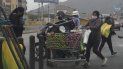 Usando una mascarilla para protegerse del nuevo coronavirus, una mujer joven mueve limones y cebollas en un carrito de compras al mercado en el distrito El Rimac en Lima, Perú, el miércoles 27 de mayo de 2020. Usando una mascarilla para protegerse del nuevo coronavirus, una mujer joven mueve limones y cebollas en un carrito de compras al mercado en el distrito El Rimac en Lima, Perú, el miércoles 27 de mayo de 2020.