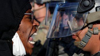   Un manifestante grita en el rostro a un efectivo de la Guardia Nacional durante una manifestación en la calle East Lake, en St. Paul, Minnesota.   