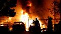 Dos personas observan un incendio provocado durante protestas en Minneapolis. Dos personas observan un incendio provocado durante protestas en Minneapolis.