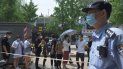 Un policía vigila mientras las personas esperan en la fila para someterse a pruebas de hisopo con coronavirus COVID-19 en una estación de prueba en Beijing el 28 de junio de 2020. Un policía vigila mientras las personas esperan en la fila para someterse a pruebas de hisopo con coronavirus COVID-19 en una estación de prueba en Beijing el 28 de junio de 2020.