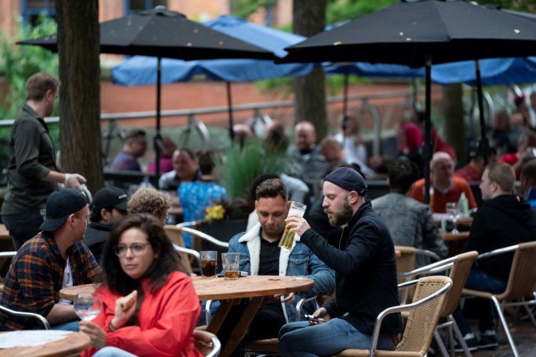 Personas sentadas en un bar en la calle Canal en la aldea gay de Manchester