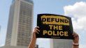 Una persona sostiene un letrero que apoya quitar fondos a la policía, el viernes 19 de junio de 2020, en St. Louis. Una persona sostiene un letrero que apoya quitar fondos a la policía, el viernes 19 de junio de 2020, en St. Louis.