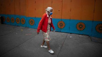 Una mujer mayor, con mascarilla para protegerse del coronavirus, camina por una calle en Caracas, Venezuela, el 17 de julio de 2020, durante la pandemia del coronavirus. 