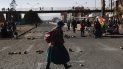 Una mujer que usa una mascarilla para prevenir el nuevo coronavirus camina por una calle bloqueada por manifestantes que protestan contra la postergación de las elecciones presidenciales en El Alto, Bolivia, el miércoles 5 de agosto de 2020. Una mujer que usa una mascarilla para prevenir el nuevo coronavirus camina por una calle bloqueada por manifestantes que protestan contra la postergación de las elecciones presidenciales en El Alto, Bolivia, el miércoles 5 de agosto de 2020.