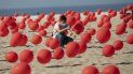 Un hombre ayuda a colocar globos rojos en la arena de la playa Copacabana durante un tributo organizado por Río de Paz para las víctimas de COVID-19 cuando el país se acerca a las 100.000 muertes por el nuevo coronavirus, en Río de Janeiro, Brasil, el sábado 8 de agosto de 2020. Un hombre ayuda a colocar globos rojos en la arena de la playa Copacabana durante un tributo organizado por Río de Paz para las víctimas de COVID-19 cuando el país se acerca a las 100.000 muertes por el nuevo coronavirus, en Río de Janeiro, Brasil, el sábado 8 de agosto de 2020.
