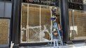 Trabajadores cubren con tablones la vidriera de una tienda de la cadena Louis Vuitton en la ciudad de Chicago. Trabajadores cubren con tablones la vidriera de una tienda de la cadena Louis Vuitton en la ciudad de Chicago.