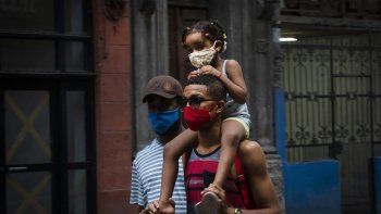 Personas con máscaras como precaución contra la propagación del nuevo coronavirus caminan en una calle de La Habana, Cuba, el 31 de agosto de 2020.