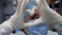Una trabajadora de salud española y voluntaria de la Fundación SAMU forma la figura de un corazón con sus manos antes de ingresar a la unidad de cuidados intensivos del Hospital El Salvador para atender a los pacientes afectados por el nuevo coronavirus, COVID-19, en San Salvador, el 12 de agosto. 2020. Una trabajadora de salud española y voluntaria de la Fundación SAMU forma la figura de un corazón con sus manos antes de ingresar a la unidad de cuidados intensivos del Hospital El Salvador para atender a los pacientes afectados por el nuevo coronavirus, COVID-19, en San Salvador, el 12 de agosto. 2020.