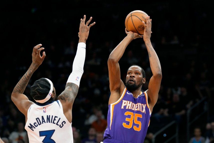 Kevin Durant, alero de los Suns de Phoenix, dispara frente a Jaden McDaniels, de los Timberwolves de Minnesota, el miércoles 29 de marzo de 2023&nbsp;