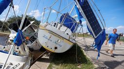 Drew Griffith camina junto a tres barcos que fueron arrastrados contra un dique tras el paso del huracán Helene en la cuenca de Seaplane de las Islas Davis, cerca del aeropuerto Peter O., el viernes 27 de septiembre de 2024 en Tampa, Florida.