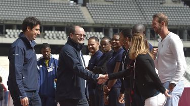 El presidente de la Comisión de Evaluación del Comité Olímpico Internacional (COI), Patrick Baumann (centro), y el co-presidente de la candidatura de París Tony Estanguet (izquierda) saludan a atletas durante su visita al Estadio de Francia en Saint Denis.
