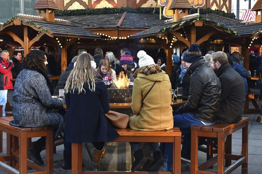 Varias personas disfrutan del mercadillo navideño de Alexanderplatz tras su reapertura este miércoles.