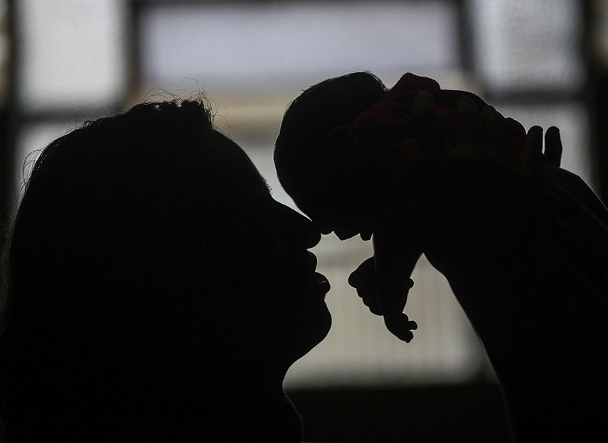 Una madre sostiene a su hija enferma con microcefalia (EFE)
