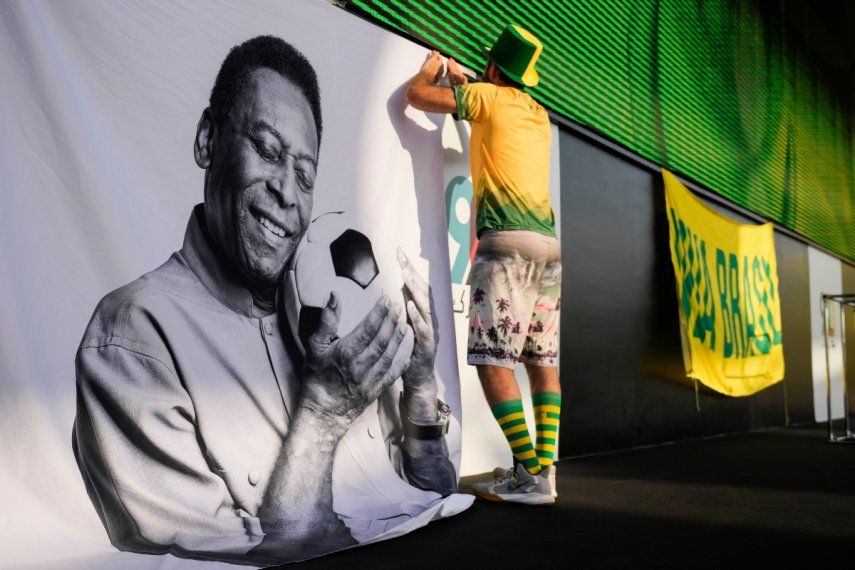 Un aficionado coloca un cartel de apoyo a Pelé en una fiesta de torcedores de Brasil, previo al partido contra Corea del Sur en los octavos de final del Mundial, el lunes 5 de diciembre de 2022, en Doha, Catar.