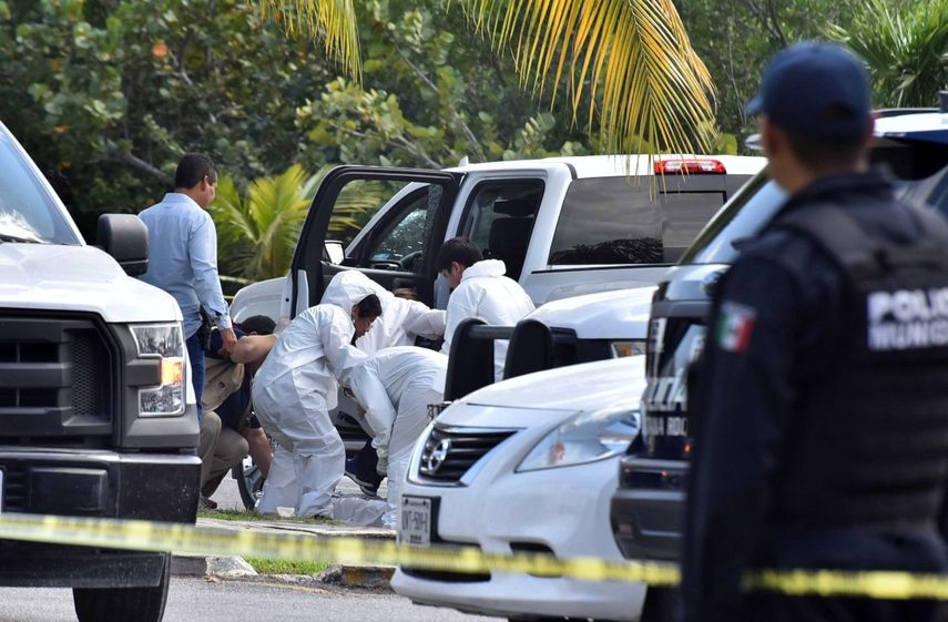 Peritos forenses inspeccionan la zona en la que hubo un enfrentamiento entre bandas rivales en Cancún (México)