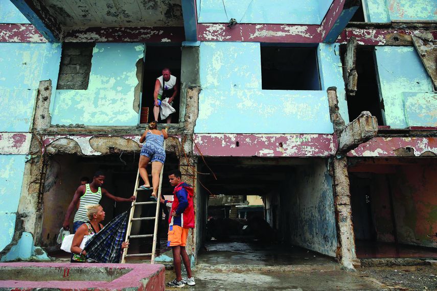 Cubanos en Baracoa revisan los destrozos dejados por el paso del huracán Matthew.