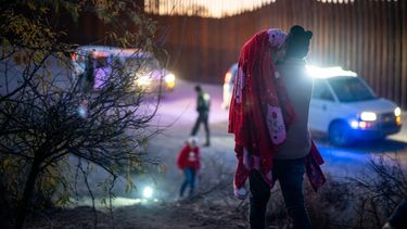 Los migrantes se entregan a los oficiales de Aduanas y Protección Fronteriza de Estados Unidos después de cruzar una sección del muro fronterizo hacia los EEUU