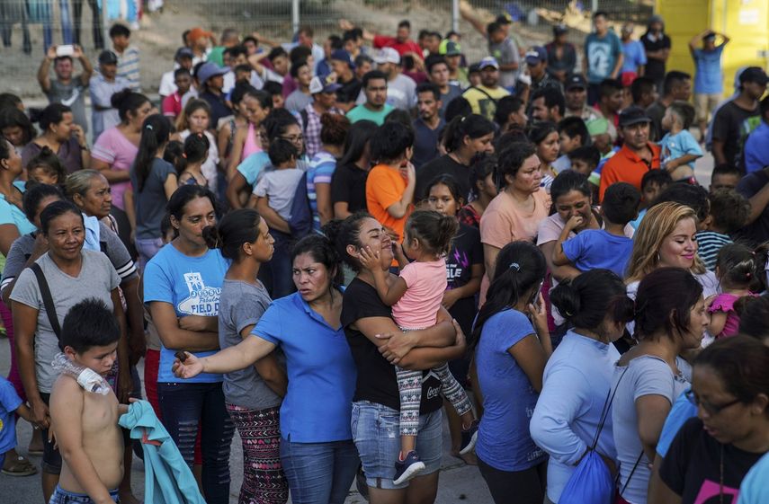 Migrantes, muchos de ellos devueltos a México por la política migratoria del entonces presidente de Estados Unidos Donald Trump, esperan en final para recibir alimentos en un campamento en el puente internacional en Matamoros, México.&nbsp;