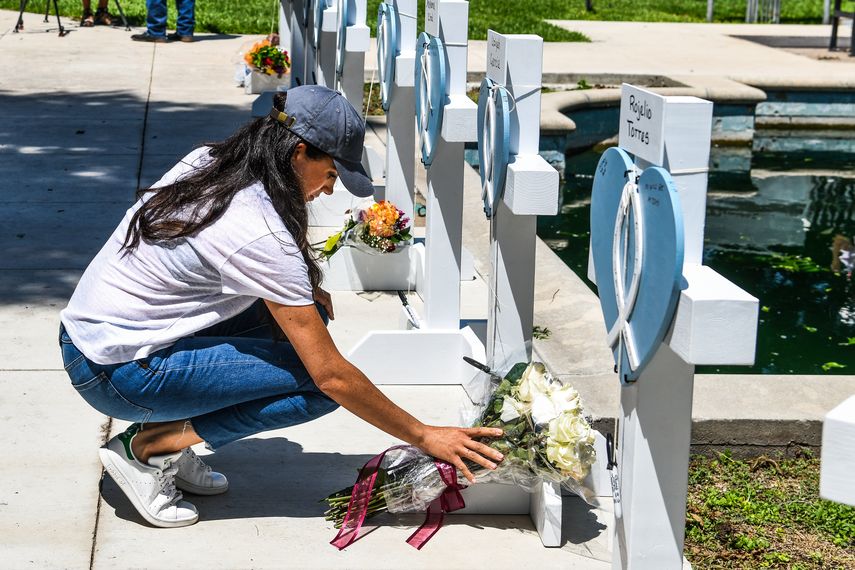 Meghan Markle, la esposa del príncipe Harry de Gran Bretaña, coloca flores mientras llora en un monumento improvisado frente al juzgado del condado de Uvalde, Texas, el 26 de mayo de 2022.