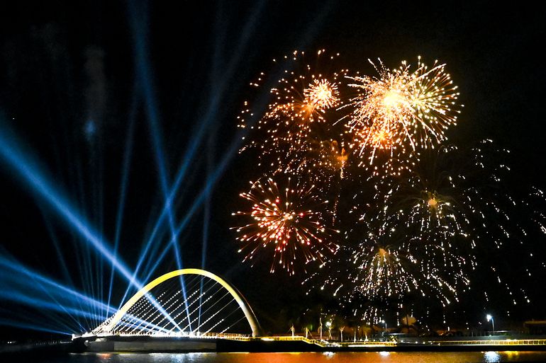Una foto tomada el 1 de enero de 2022 muestra fuegos artificiales iluminando el cielo sobre el puente de la ciudad portuaria como parte de las festividades de Año Nuevo en Colombo, Sri Lanka.   