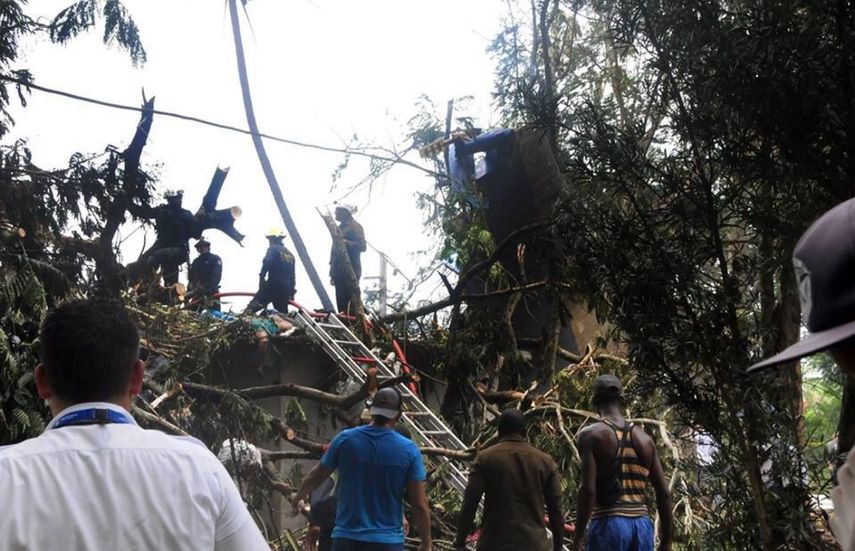 Miembros del Departamento de Bomberos de Cuba inspeccionan el lugar donde se estrelló un avión de Cubana de Aviación este viernes 18 de mayo, en las inmediaciones del Aeropuerto Internacional José Martí de La Habana.