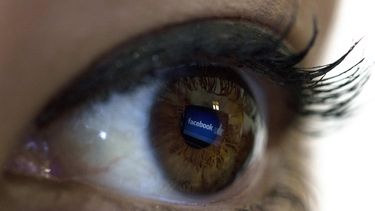 Vista del reflejo del logo de la red social&nbsp;Facebook en el ojo de una mujer.&nbsp;