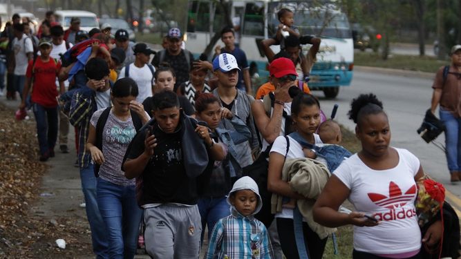En esta foto de archivo del 10 de abril de 2019, migrantes caminan poco después del amanecer en San Pedro Sula, Honduras, como parte de una caravana rumbo a Estados Unidos.