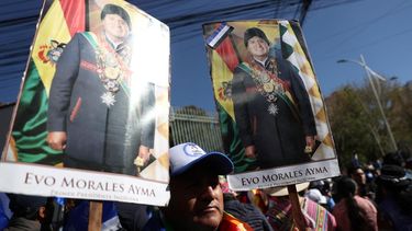 Un seguidor del expresidente de Bolivia Evo Morales, al sostener carteles con imágenes del exmandatario, a las afueras de la sede del Tribunal Supremo Electoral (TSE) de Bolivia, en La Paz.
