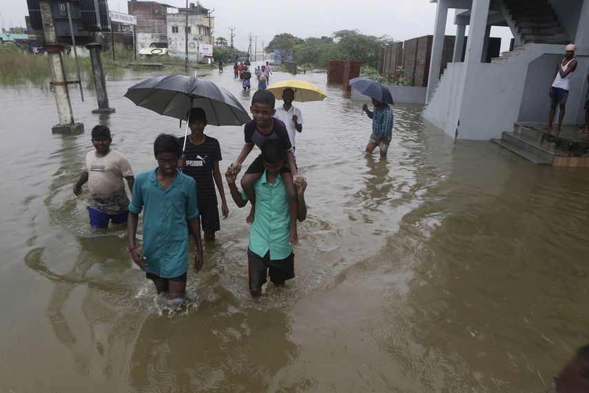 Unos ni&ntilde;os caminan por una calle inundada por las tormentas en Chennai, India, el lunes 2 de diciembre de 2019.&nbsp;