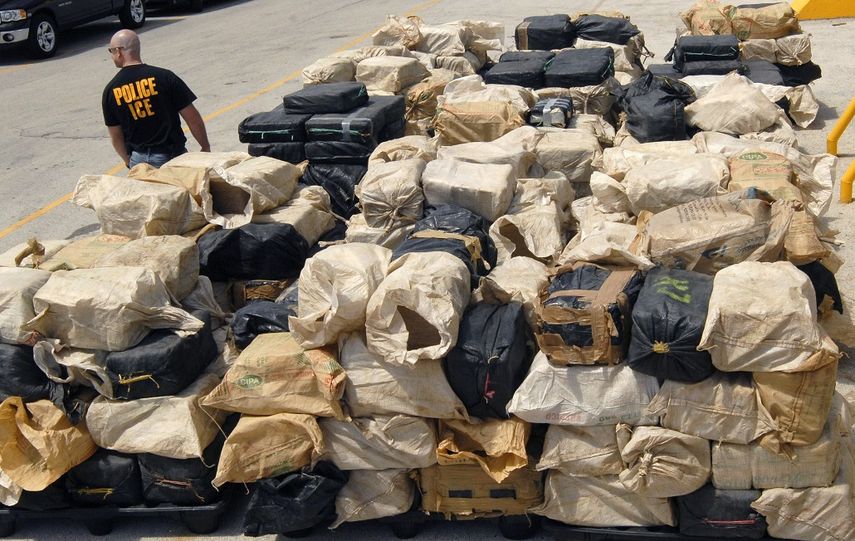 Un agente de la Oficina de Inmigración y Aduanas de Miami vigila los más de 13 mil kilos de cocaína pura que fueron depositados en un muelle de Florida. La cocaína suele ser entregada a la Agencia Antidrogas de EEUU (DEA) para su destrucción y uso en el proceso judicial.&nbsp;