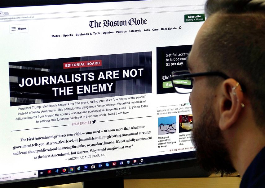 Un hombre visita el portal web de The Boston Globe en el que se lee Los periodistas no son el enemigo.