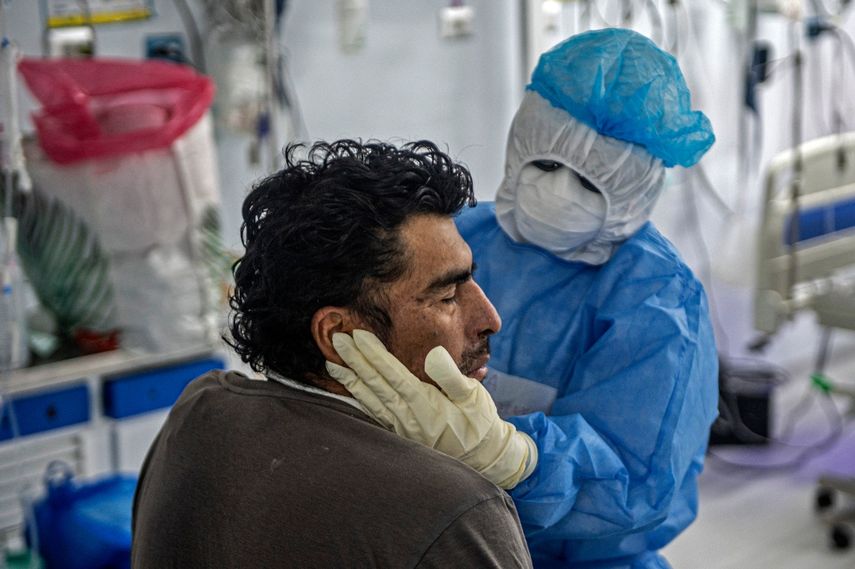 Una enfermera (2-R) realiza fisioterapia en un paciente con COVID-19 en la Unidad de Cuidados Intensivos del Hospital Alberto Sabogal Sologuren, en Lima, el 2 de julio de 2020, en medio de la nueva pandemia de coronavirus.