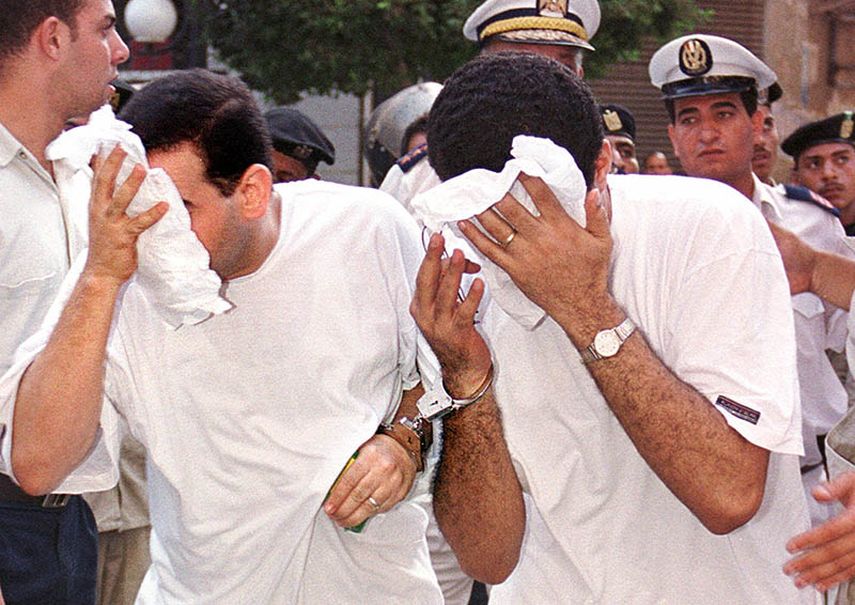 En esta fotografía de archivo del 18 de julio de 2001, dos de 52 hombres acusados de violar las leyes sobre obscenidad y moral pública -presentados frecuentemente en el país contra homosexuales- se cubren los rostros al ingresar a una corte en El Cairo