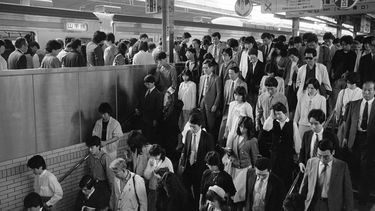 La gente sale del andén de una estación de tren a lo largo de la línea Yamanote en Tokio, Japón,  el 26 de abril de 1986.