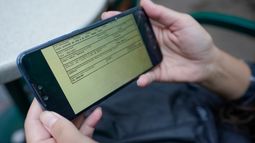 La venezolana Candy Cegarra muestra una foto de un documento en su celular durante una entrevista con The Associated Press, donde la Oficina de Aduanas y Protección Fronteriza de Estados Unidos escribió la dirección de una iglesia en El Paso como su dirección.