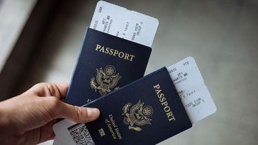 Una mujer muestra dos pasaportes estadounidenses.