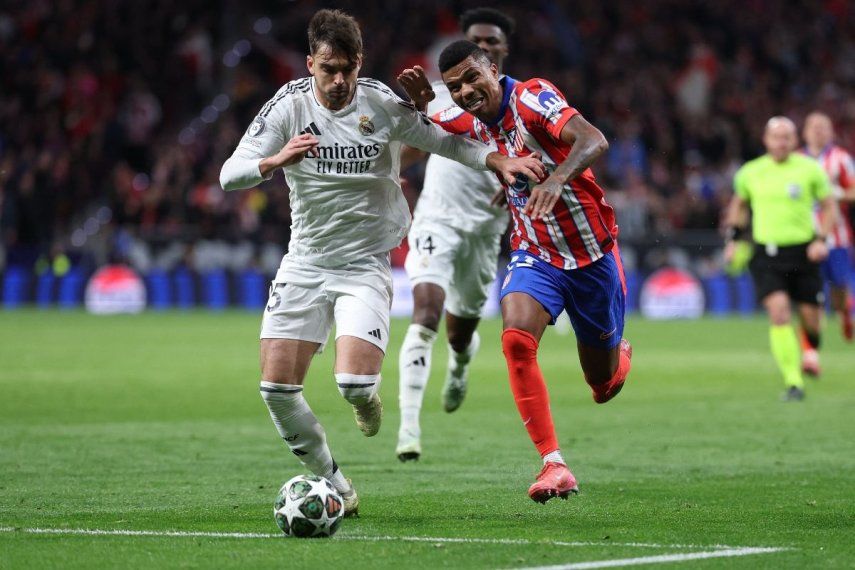 El defensa español #35 del Real Madrid, Raúl Asencio, y el defensa mozambiqueño #23 del Atlético de Madrid, Reinildo Mandava, disputan el balón durante el partido de vuelta de los octavos de final de la UEFA Champions League entre el Club Atlético de Madrid y el Real Madrid CF en el estadio Metropolitano de Madrid el 12 de marzo de 2025. 