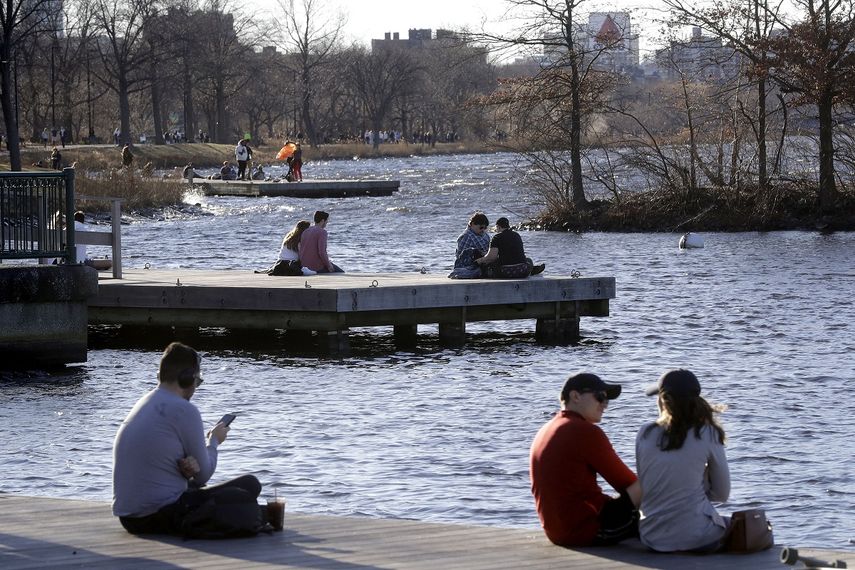 En esta fotografía de archivo del domingo 12 de enero de 2020, numerosas personas descansan en un embarcadero del parque Espalande del río Charles, en Boston, durante un clima cálido extemporáneo de alrededor de 21 grados en diversos lugares del estado. 