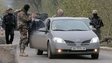 Individuos armados pro rusos controlan un camino tras un enfrentamiento en un retén bajo control de activistas pro rusos en la aldea de Bulbasika, cerca de la ciudad de Slovyansk, Ucrania. (AP Foto/Efrem Lukatsky)