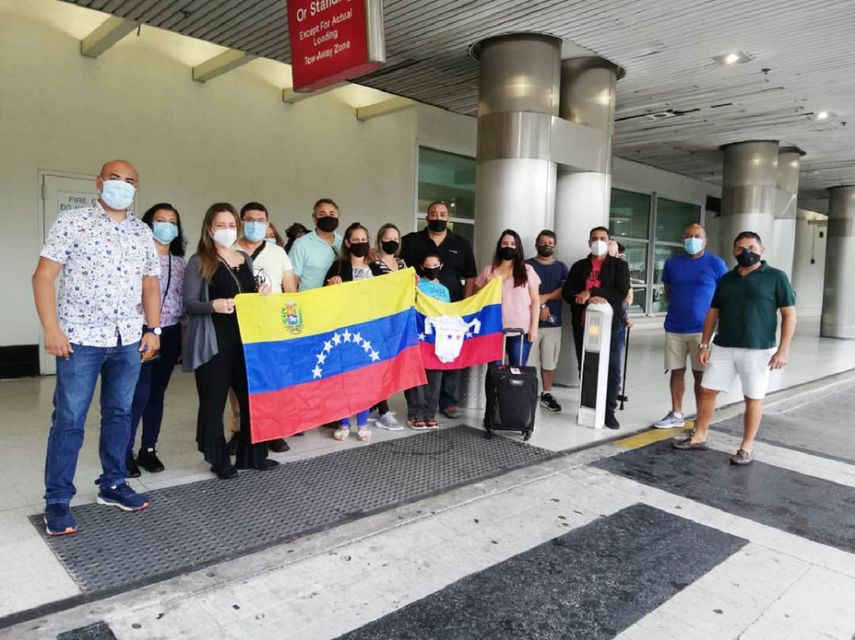 Esta foto proporcionada por Cristina Mujica muestra a ciudadanos venezolanos sosteniendo la bandera de su pa&iacute;s en el Aeropuerto Internacional de Miami en julio de 2020 donde est&aacute;n varados, incluida Mujica.&nbsp;